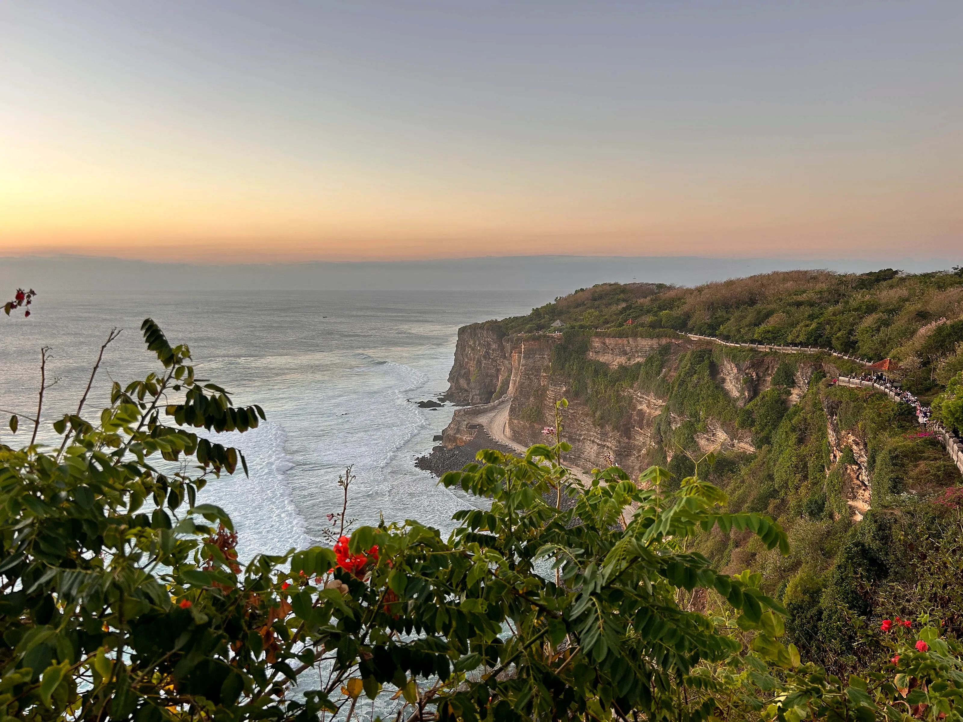 El acantilado de Uluwatu al atardecer: el camino con barandilla que recorre el borde lleva al templo y al anfiteatro de la danza.