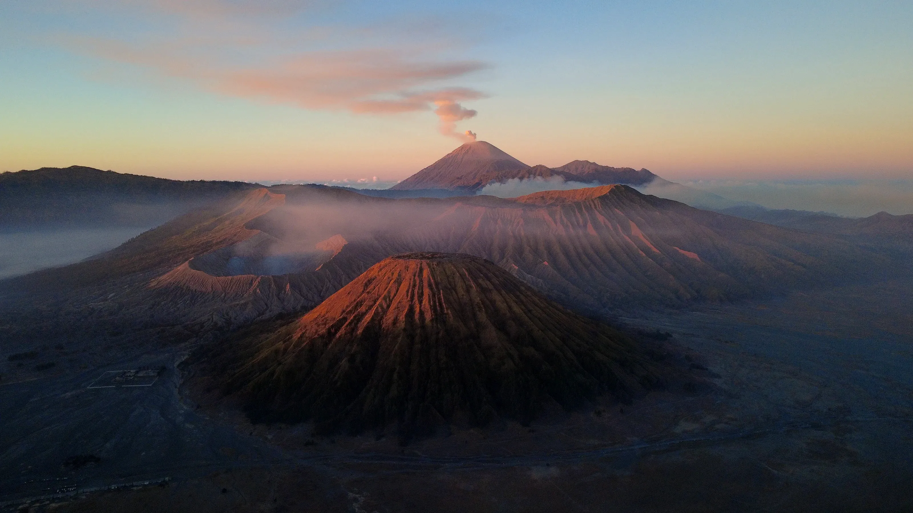 El Bromo humeando al amanecer, con el Semeru al fondo y el mar de nubes en la caldera.